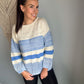 Girl wearing knit sweater that is blue and cream. 