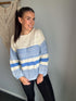 Girl wearing knit sweater that is blue and cream. 
