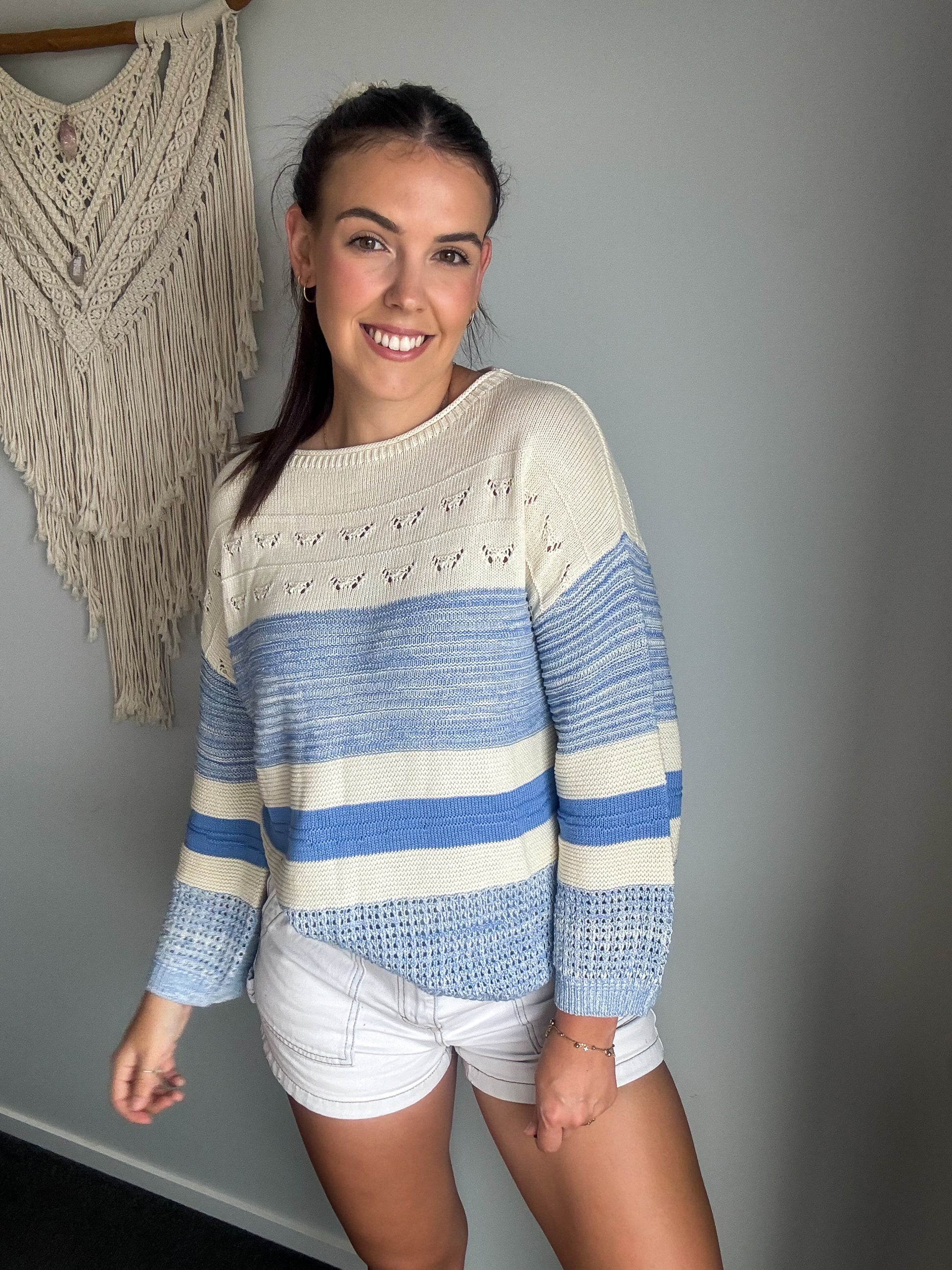 Girl wearing knit sweater that is blue and cream. 