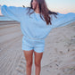 Person wearing a blue checkered outfit on a sandy beach