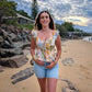 Woman standing on a beach with rocks and trees in the background