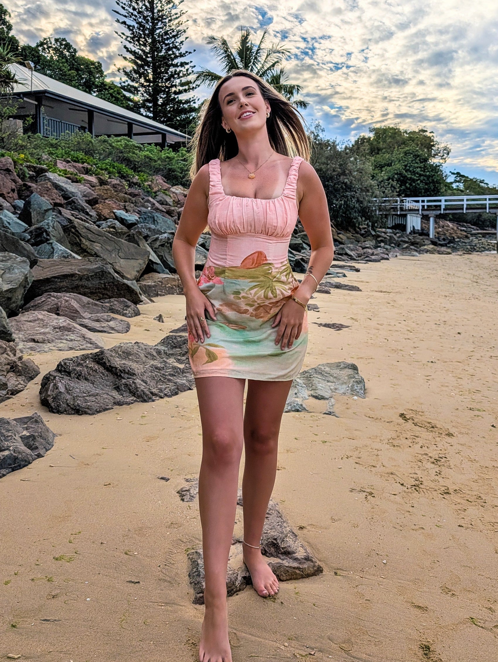 Woman standing on a beach with a scenic background