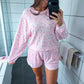 Woman taking a mirror selfie wearing a pink loungewear set in a bathroom.