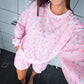 Person wearing a pink floral loungewear set in a bathroom.